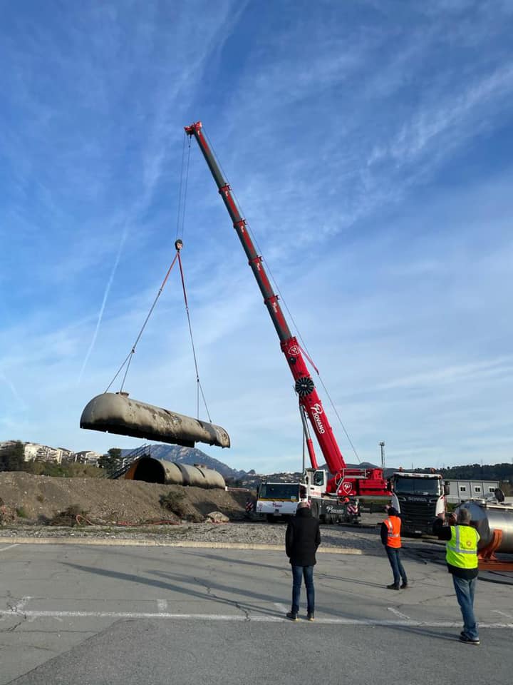 Grue soulevant un tuyau industriel